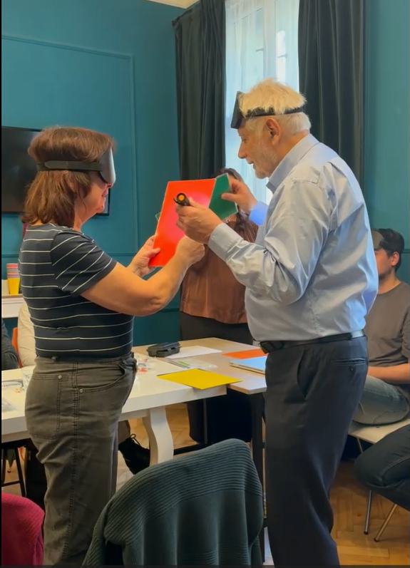 Mark Komissarov teaching a partner exercise at his final InfoVision seminar: a participant holds a coloured sheet while he works with a blackout mask.